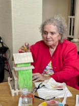 Memory care resident Trudy painting a bird house